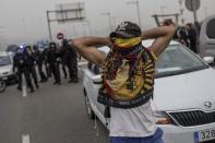 Un manifestante se cubre la cara en los accesos al recinto, bloqueados (AP Photo/Bernat Armangue)