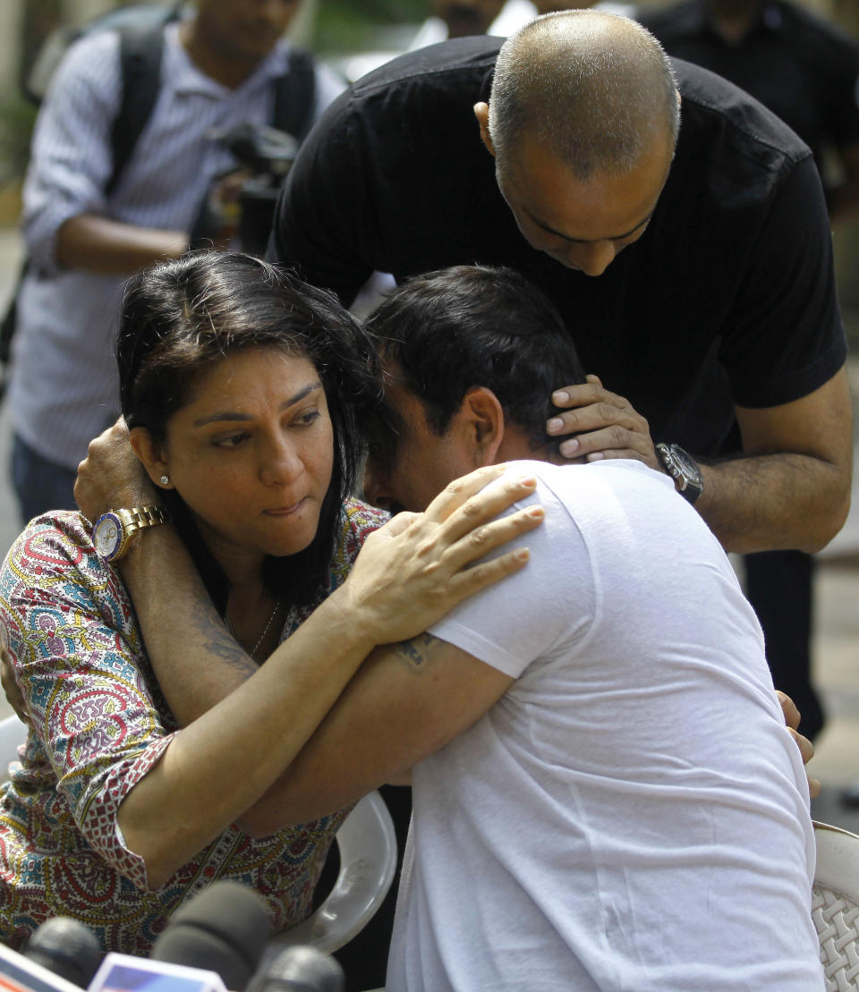 Indian Bollywood actor Sanjay Dutt, right, breaks down as his sister Priya Dutt tries to console him during a press conference at his residence in Mumbai, India, Thursday, March 28, 2013. Dutt said he has not sought pardon for a 1993 weapons conviction and will serve his prison sentence as ordered by India's Supreme Court. Dutt broke his silence a week after the court sentenced him to five years in prison for illegal possession of weapons supplied by Mumbai crime bosses linked to a 1993 terror attack that killed 257 people.(AP Photo/Rafiq Maqbool)