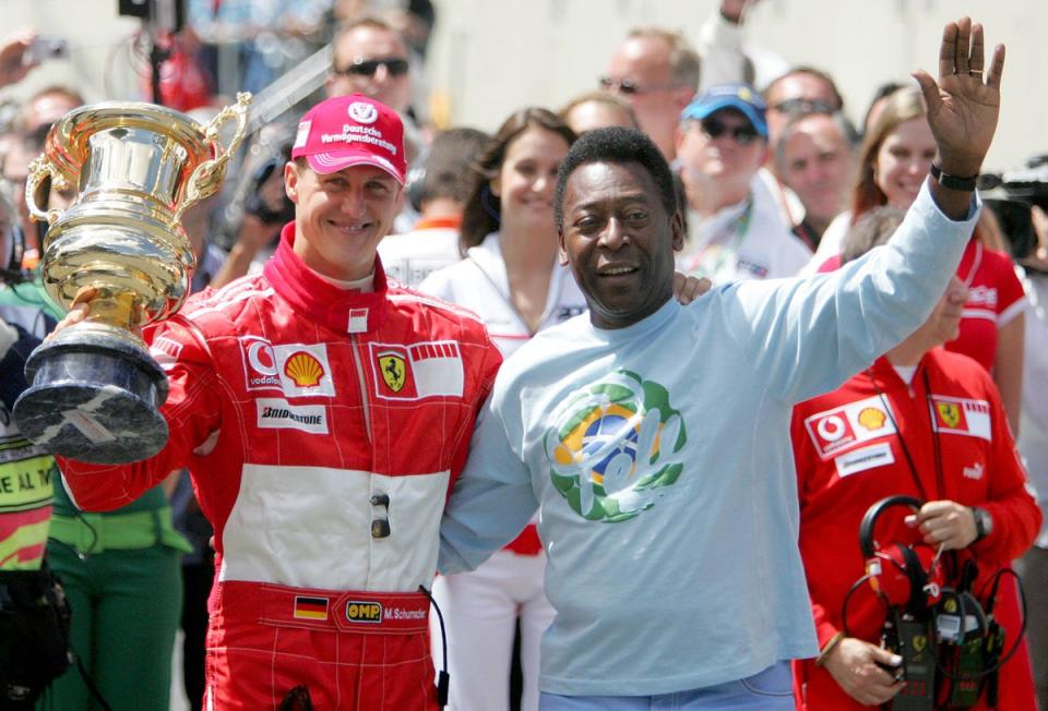 Michael Schumacher of Germany and Ferrari receives a trophy for his achievements in F1 racing from Pele during the Brazilian Formula One Grand Prix at the Autodromo Interlagos on October 22, 2006 in Sao Paulo, Brazil. (Getty Images)