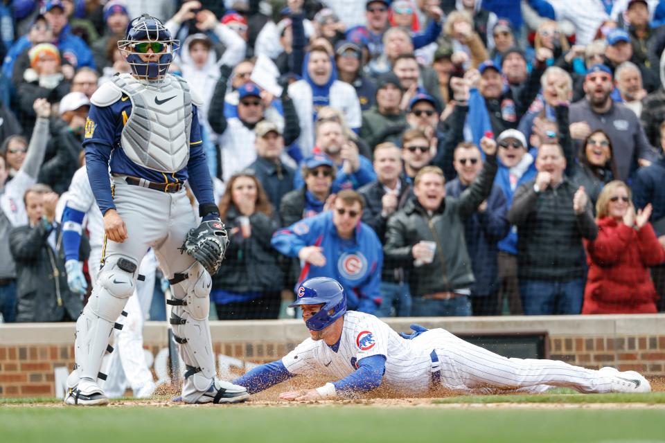 Cubs second baseman Nico Hoerner slides to score past Brewers catcher William Contreras during the third inning at Wrigley Field on Thursday.