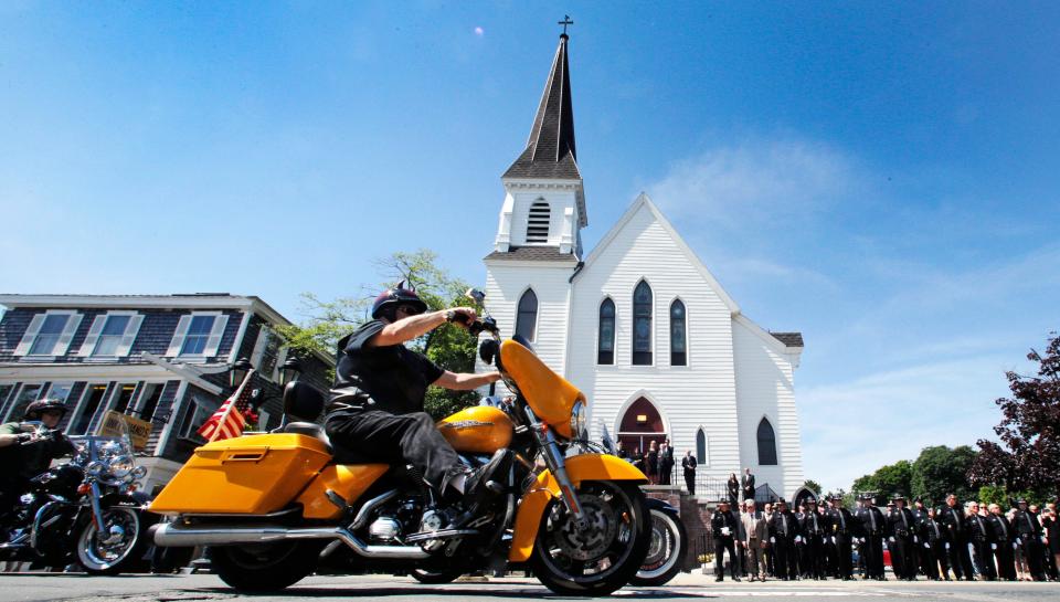 Members of the Jarheads Motorcycle Club pass police honor guards as they roll up to the funeral for Michael Ferazzi at St. Peter's Catholic Church in Plymouth, Mass., Friday, June 28, 2019.