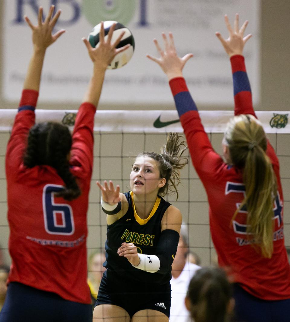 Forest Wildcats' Kailyn Howard (6) spikes one through the hands of two Vanguard defenders during their volleyball match at Forest High School in Ocala , on Thursday, Sept. 22, 2022.