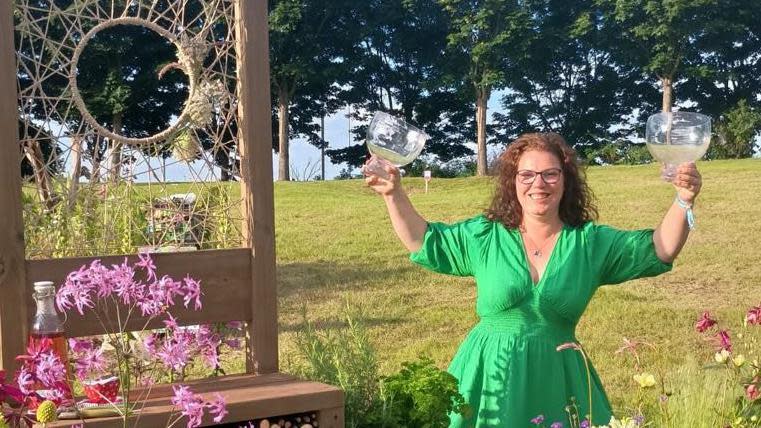 Leanne Wood with long curly brown hair standing next to her garden