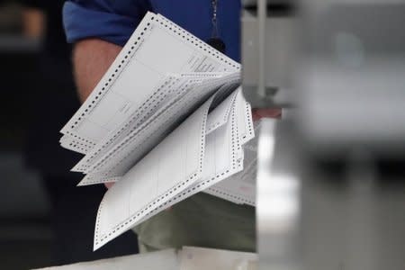 FILE PHOTO: A worker holds ballots before a ballot recount in Lauderhill, Florida, U.S., November 12, 2018. REUTERS/Carlo Allegri/File Photo