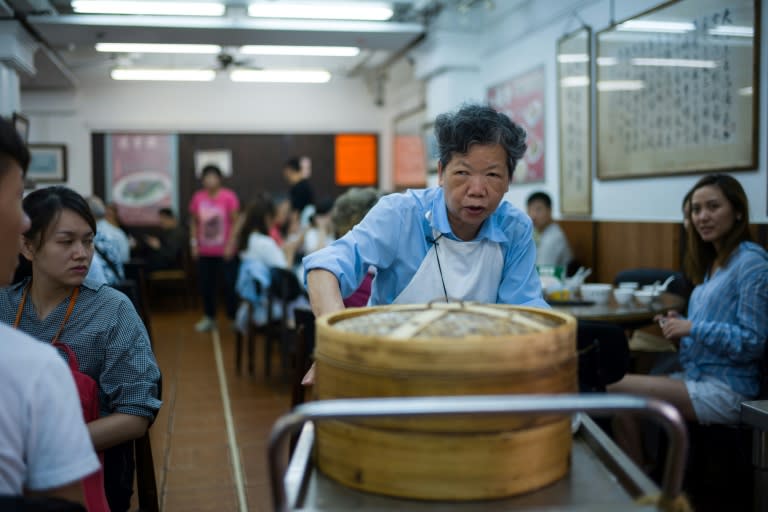 Steamed dim sum dishes are distributed by fierce looking "trolley aunties"