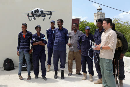 Somali police officers watch instructor Brett Velicovich (R) fly a DJI Inspire drone during a drone training session for Somali police in Mogadishu, Somalia May 25, 2017. Picture taken May 25, 2017. REUTERS/Feisal Omar