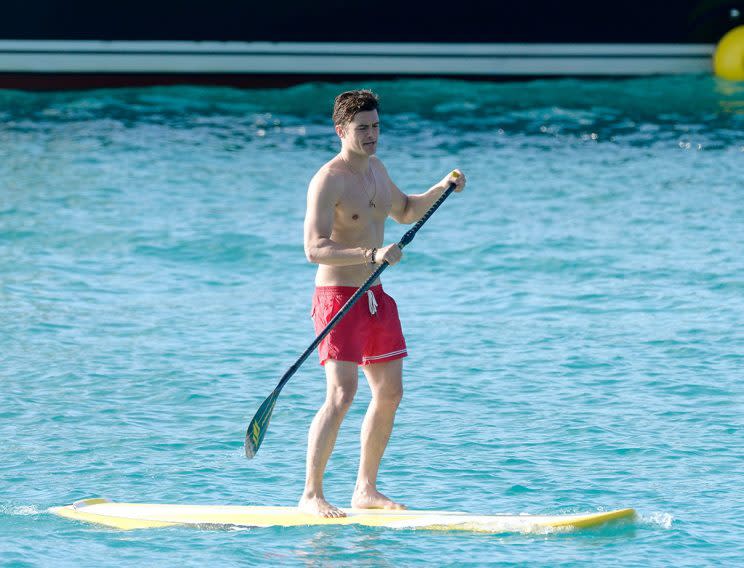 Orlando Bloom enjoying the view on a Caribbean beach with Australian model Kristy Hinze Clark.