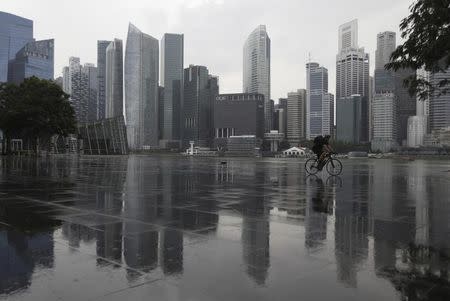 A cyclist rides past the skyline of the Central Business District in Singapore January 3, 2013. REUTERS/Edgar Su