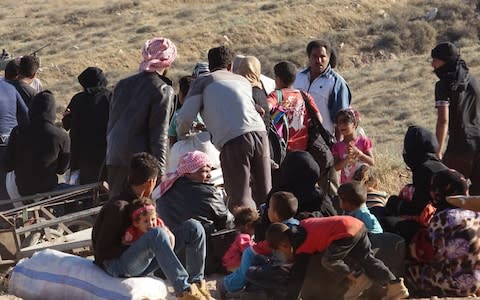 Syrians wait at the border areas near Jordan after they fled from the ongoing military operations by Bashar al-Assad regime  - Credit: Ammar Al Ali /Anadolu Agency/Getty Images