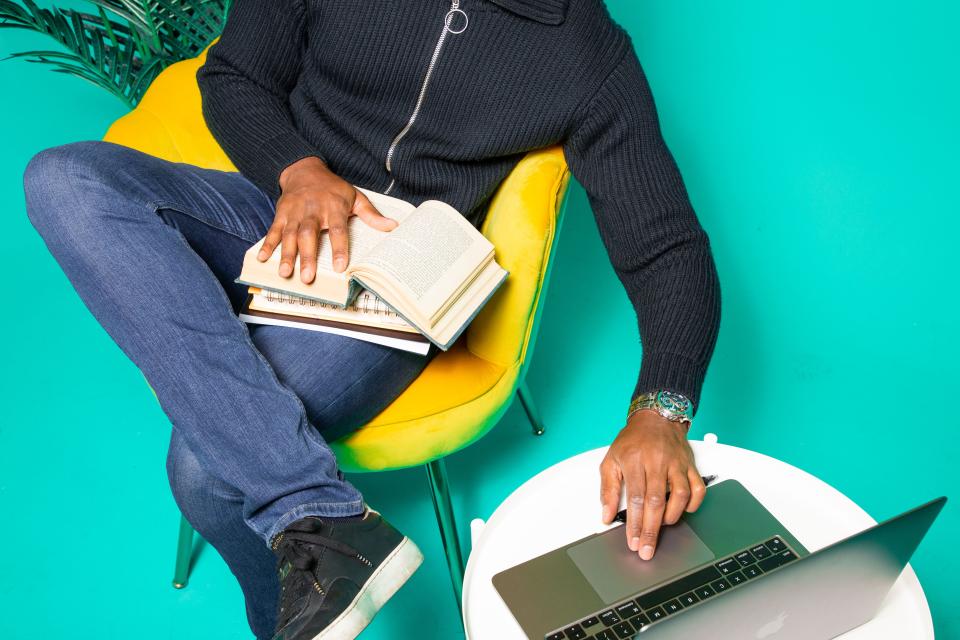 man with books and laptop