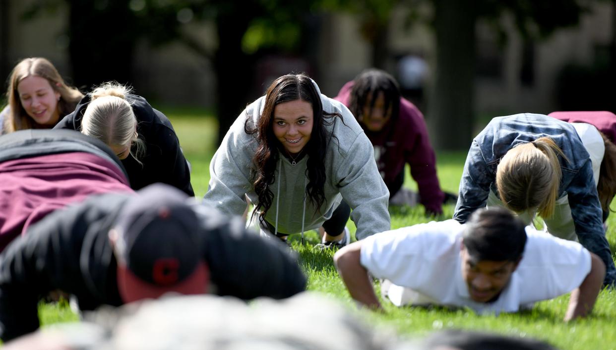 Walsh University freshman McKenzee Roseburrough does pushups Thursday in recognition of National Suicide Prevention Week. Members of the military and Walsh students, faculty and staff were challenged to do 22 pushups, each one representing a veteran who dies from suicide every day.