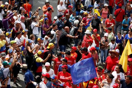 Partidarios (de rojo) y opositores al gobierno del presidente Nicolás Maduro discuten durante una marcha en Caracas. 19 de abril de 2017. Un joven fue herido de bala el miércoles, dijeron testigos de Reuters, durante una nueva jornada de protestas opositoras en Caracas en contra del presidente Nicolás Maduro. REUTERS/Carlos Garcia Rawlins