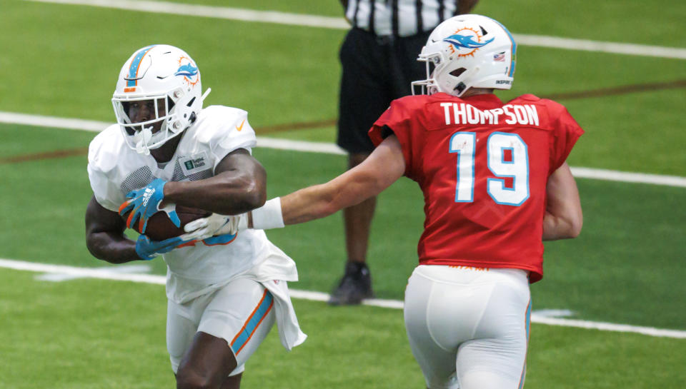 Miami Dolphins quarterback Skylar Thompson (19) hand off to running back Sony Michel (28) during NFL football training camp at Baptist Health Training Complex in Hard Rock Stadium on Thursday, Aug. 18, 2022 in Miami Gardens, Fla. (David Santiago/Miami Herald via AP)