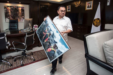 Indonesia's former energy and mining minister Sudirman Said holds his picture as walks shortly before leaving the Energy and Mining Minister's office in Jakarta, Indonesia, July 27, 2016. Antara Foto/Muhammad Adimaja/via REUTERS