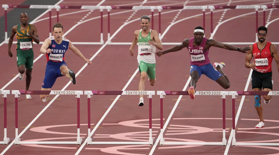 Karsten Warholm, of Norway, second left, clears the final hurdle to beat Rai Benjamin, of United States to win a semifinal of the men's 400-meter hurdles at the 2020 Summer Olympics, Sunday, Aug. 1, 2021, in Tokyo, Japan. (AP Photo/Charlie Riedel)