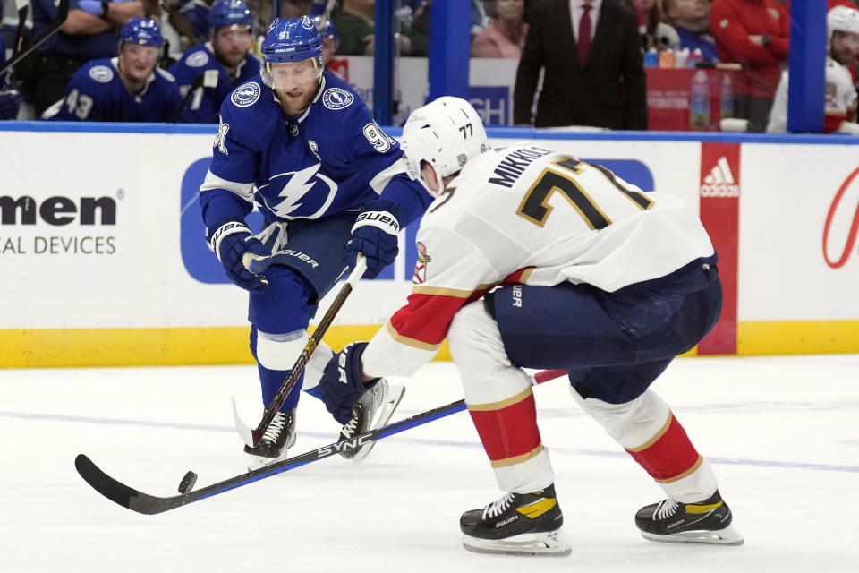 Tampa Bay Lightning center Steven Stamkos (91) tries to get the puck past Florida Panthers defenseman Niko Mikkola (77) during the second period of an NHL hockey game Wednesday, Dec. 27, 2023, in Tampa, Fla. (AP Photo/Chris O'Meara)