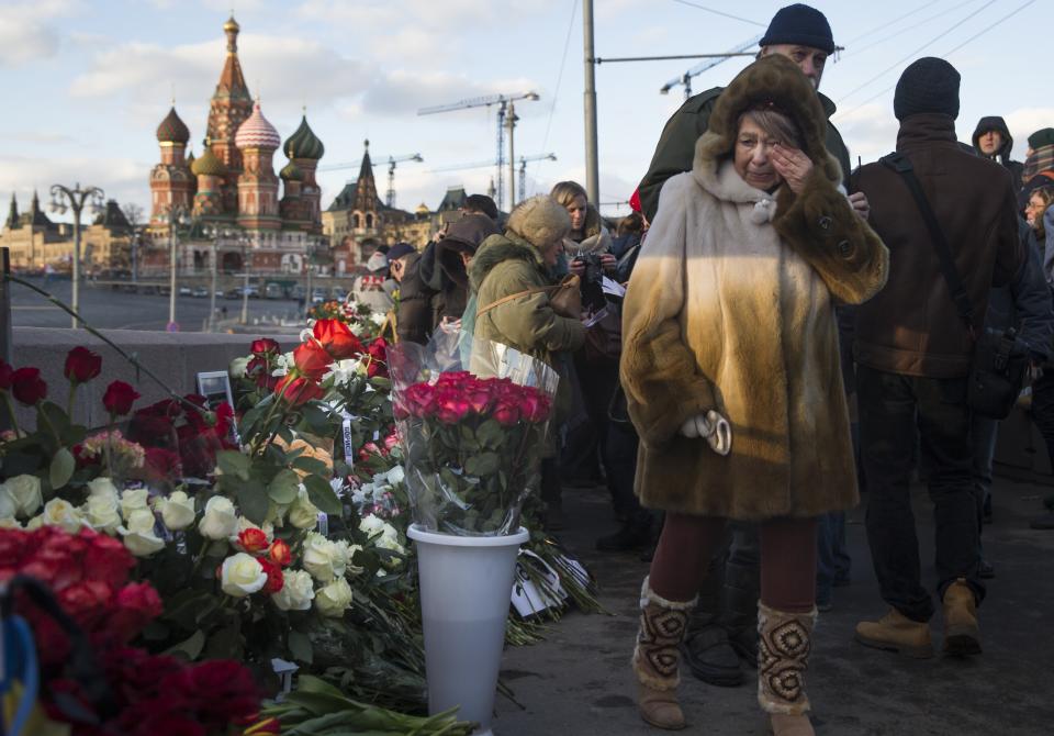 FILE - People lay flowers at the place where Russian opposition leader Boris Nemtsov was gunned down in 2015 on a bridge near the Kremlin in Moscow, Russia, with St. Basil Cathedral in the background, on Saturday, Feb. 27, 2016. His death brought thousands into the streets of Moscow, where they were allowed to protest unimpeded by police – unlike after the scene after the Feb. 16, 2024, death in prison of Alexei Navalny, a political foe of President Vladimir Putin. Mourners trying to lay flowers at makeshift memorials to Navalny were quickly arrested. (AP Photo/Pavel Golovkin, File)