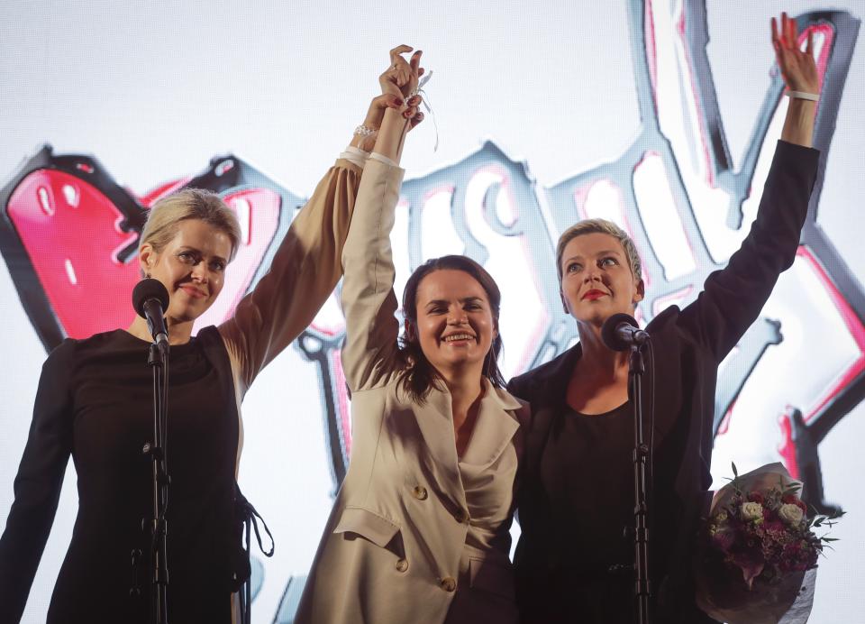 Maria Kolesnikova, a representative of Viktor Babariko, right, Svetlana Tikhanovskaya, candidate for the presidential elections, centre, and wife of non-registered candidate Valery Tsepkalo, Veronika Tsepkalo, left, gesture during meeting in support of Svetlana Tikhanovskaya in Minsk, Belarus, Thursday, July 30, 2020. Thousands of Tikhanovskaya's supporters gathered Thursday at her campaign rally in Minsk. The presidential election in Belarus is scheduled for August 9, 2020. (AP Photo/Sergei Grits)