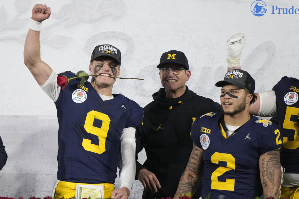 Michigan quarterback J.J. McCarthy (9), head coach Jim Harbaugh and running back Blake Corum (2) celebrate on the podium after a win over Alabama in the Rose Bowl CFP NCAA semifinal college football game Monday, Jan. 1, 2024, in Pasadena, Calif. (AP Photo/Mark J. Terrill)