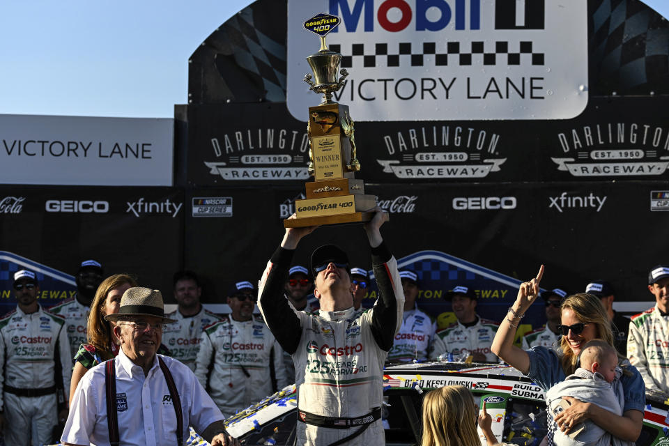 Driver Brad Keselowski holds up a trophy in Victory Lane after winning a NASCAR Cup Series auto race at Darlington Raceway, Sunday, May 12, 2024, in Darlington, S.C. (AP Photo/Matt Kelley)