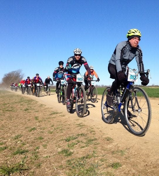 Cyclists ride one of the easiest stretches of dirt roads in the Melting Mann race through Cass County.