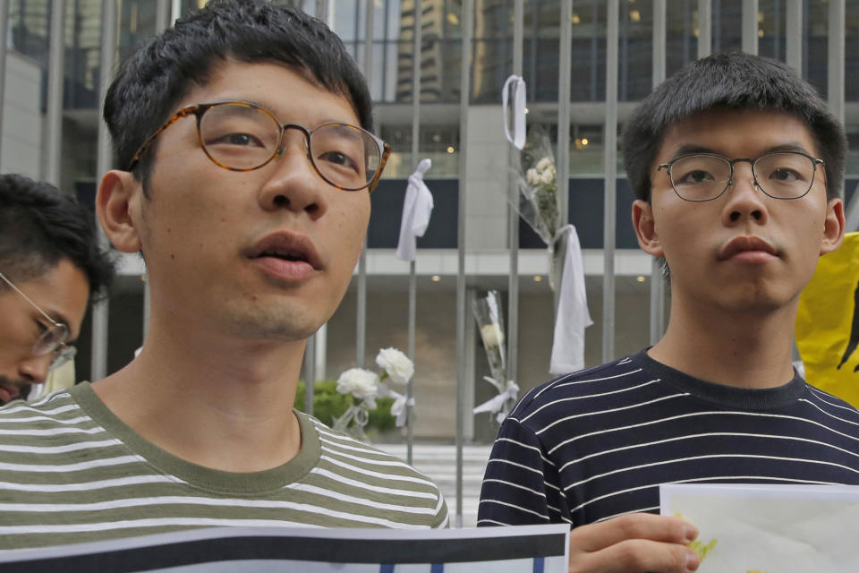 FILE - In this June 18, 2019, file photo, pro-democracy activists Nathan Law, left, and Joshua Wong speak to the media outside government office in Hong Kong. Prominent Hong Kong democracy activist Nathan Law has left the city for an undisclosed location, he revealed on his Facebook page shortly after testifying at a U.S. congressional hearing about the tough national security law China had imposed on the semi-autonomous territory. In his post late Thursday, July 2, 2020, he said that he decided to take on the responsibility for advocating for Hong Kong internationally and had since left the city. (AP Photo/Kin Cheung, File)