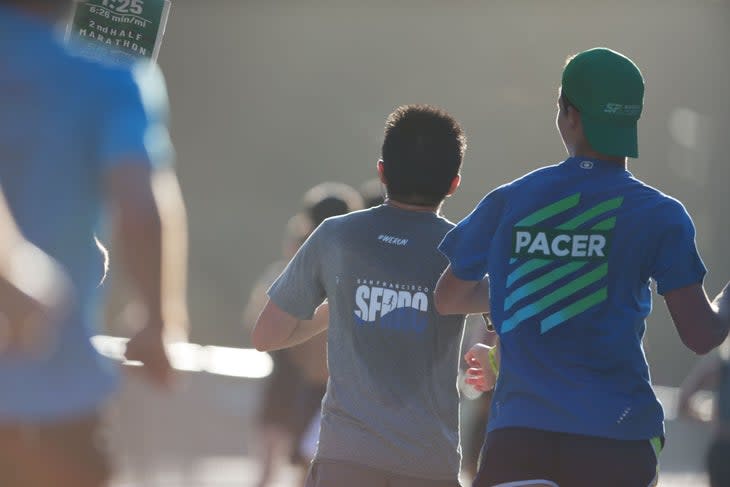 <span class="article__caption">A pacer and a half-marathon runner run side by side on the course.</span>
