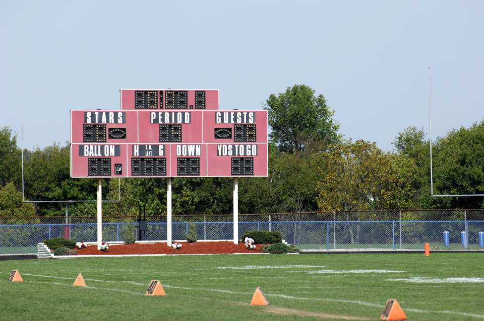 School football field with scoreboard in daytime.
