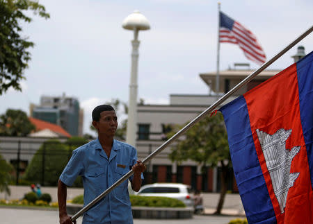 A man holds a Cambodian flag opposite the U.S. Embassy in Phnom Penh, Cambodia, April 13, 2018. REUTERS/Samrang Pring