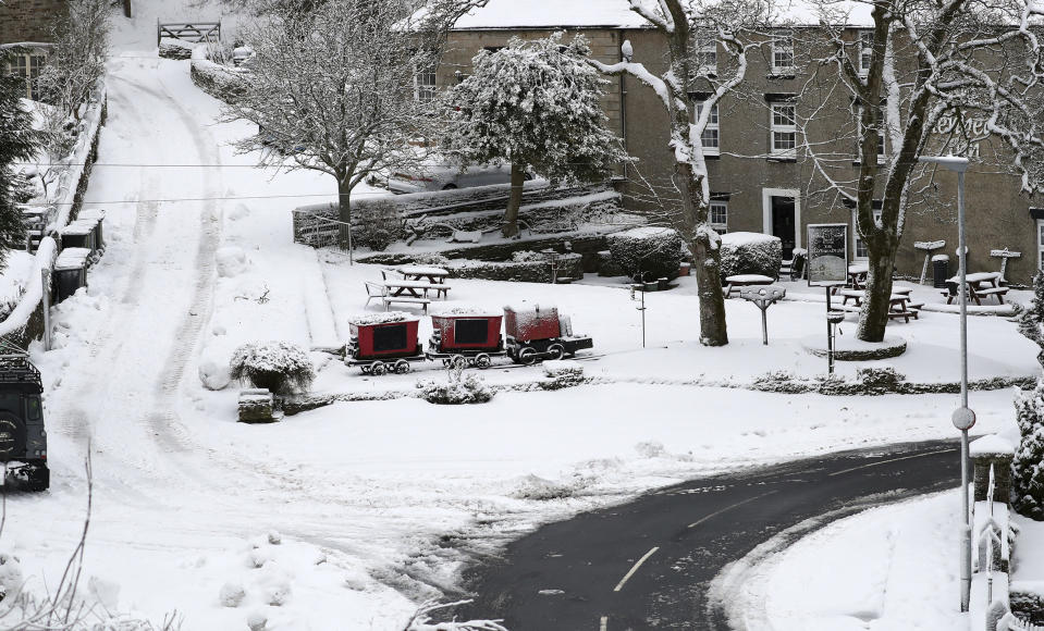 The snow covered scene with one road clear for road traffic at Allenheads, England, Sunday, Feb. 7, 2021. Snow has swept across the region Sunday, with further snowfall predicted to impact on the country bringing travel problems as temperatures drop. (AP Photo/Scott Heppell)