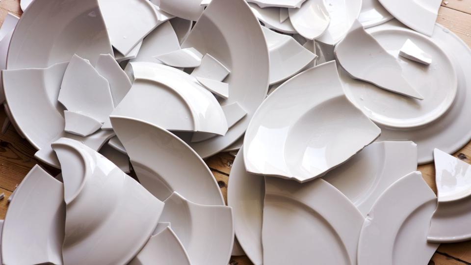 white broken plates on a wooden floor