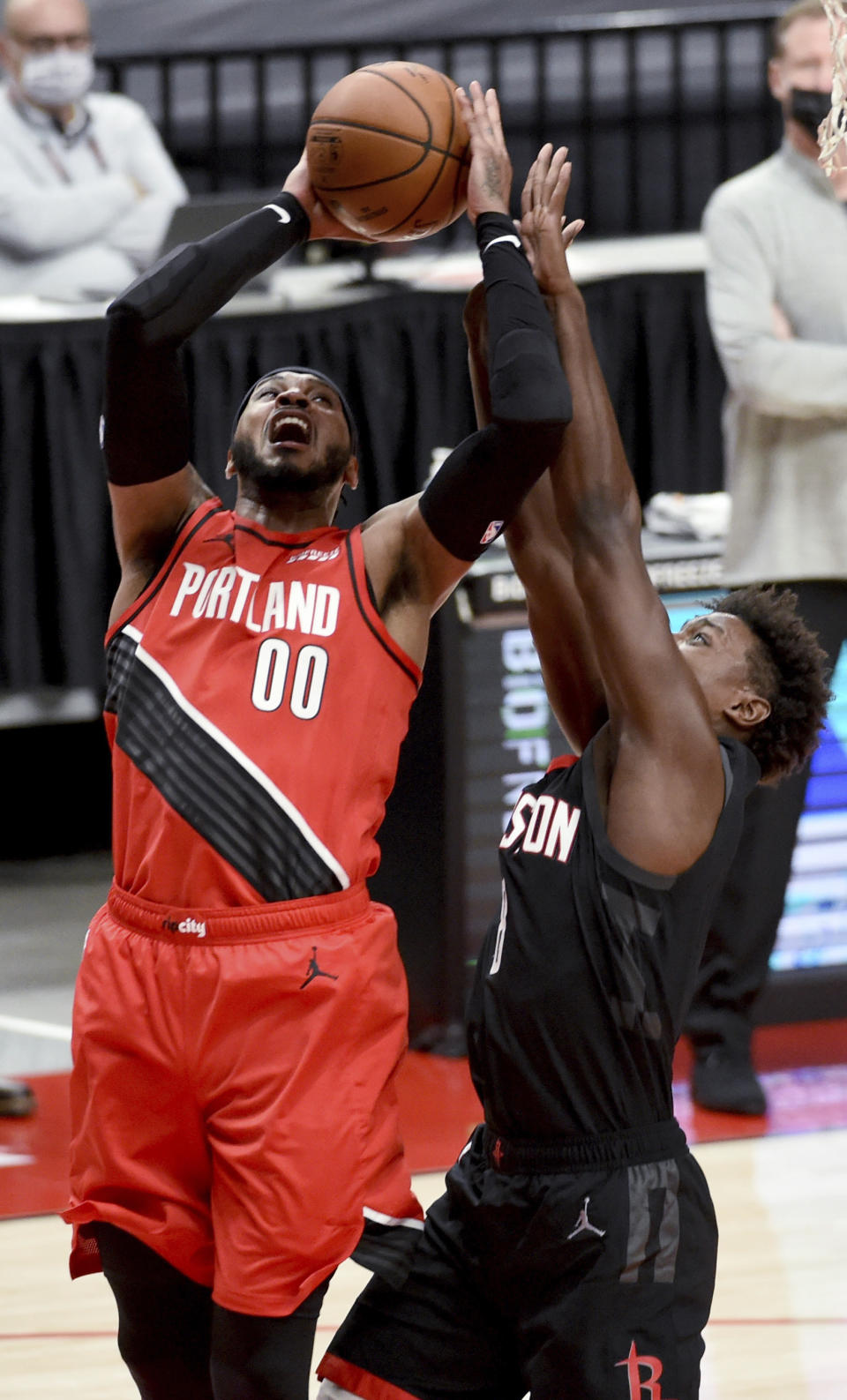 Portland Trail Blazers forward Carmelo Anthony, left, shoots over Houston Rockets forward Jae'Sean Tate during the first half of an NBA basketball game in Portland, Ore., Saturday, Dec. 26, 2020. (AP Photo/Steve Dykes)