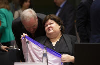 Belgian Health Minister Maggie De Block folds a scarf during an extraordinary meeting of EU health ministers in Brussels to discuss the Covid-19 virus outbreak, Friday, March 6, 2020. Fearing a possible shortage in medicine and protective masks, health ministers from the European Union are trying to boost their collective response to the novel coronavirus outbreak during an emergency meeting. (AP Photo/Virginia Mayo)