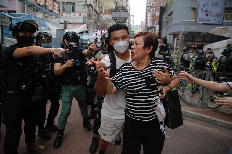 A woman argues with police as she was told to stay away from the area in Mongkok, Hong Kong, Wednesday, May 27, 2020. Thousands of protesters shouted pro-democracy slogans and insults at police in Hong Kong before lawmakers later Wednesday debate a bill criminalizing abuse of the Chinese national anthem in the semi-autonomous city. (AP Photo/Kin Cheung)