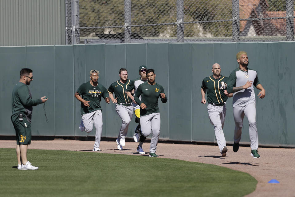 Oakland Athletics' Sean Manaea, front, leads a group of pitchers running during spring training baseball practice, Thursday, Feb. 13, 2020, in Mesa, Ariz. (AP Photo/Darron Cummings)