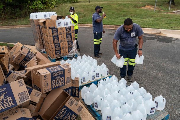 PHOTO: Workers with the Baltimore City Department of Public Works distribute jugs of water to city residents at the Landsdowne Branch of the Baltimore County Library on Sept. 6, 2022 in Baltimore, Maryland. (Drew Angerer/Getty Images)