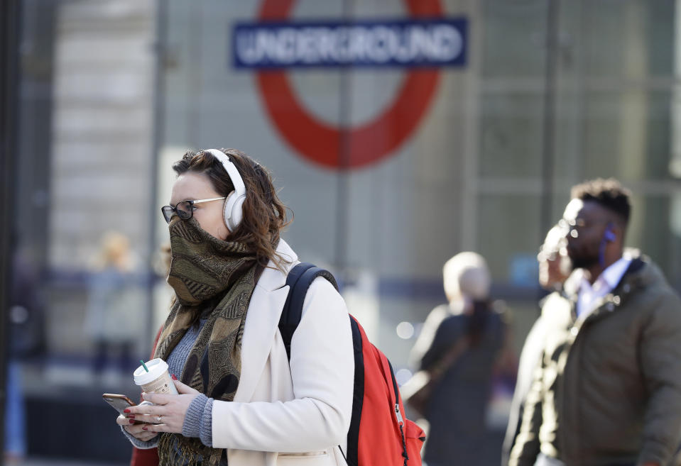 A commuter covers her face in London, Monday, March 16, 2020. For most people, the new coronavirus causes only mild or moderate symptoms, such as fever and cough. For some, especially older adults and people with existing health problems, it can cause more severe illness, including pneumonia. (AP Photo/Kirsty Wigglesworth)