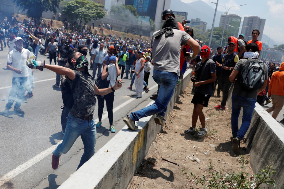 Opposition demonstrators clash with security forces near the Generalisimo Francisco de Miranda Airbase “La Carlota” in Caracas