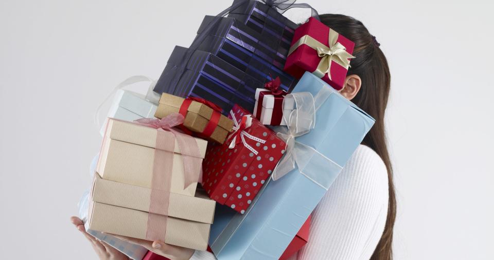 Woman carrying too many gift boxes