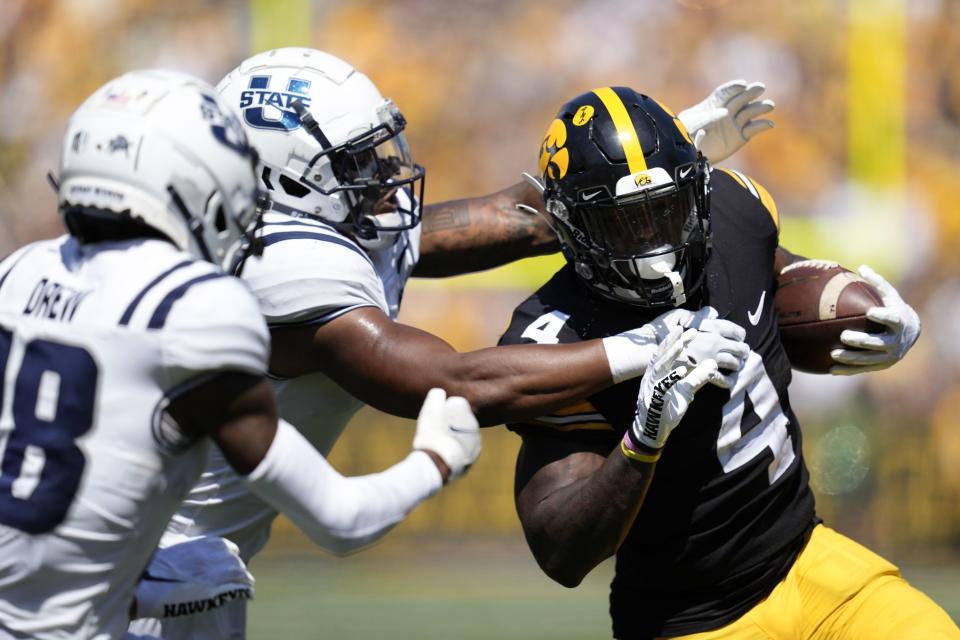 Iowa running back Leshon Williams (4) tries to break a tackle by Utah State safety Anthony Switzer during the first half of an NCAA college football game, Saturday, Sept. 2, 2023, in Iowa City, Iowa. (AP Photo/Charlie Neibergall) | AP