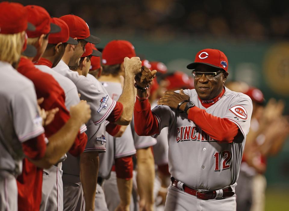 Reds manager Dusty Baker (12) bumps fists with his players before the start of their Wild Card play-off game against the Pittsburgh Pirates played at PNC Park on October 1, 2013.