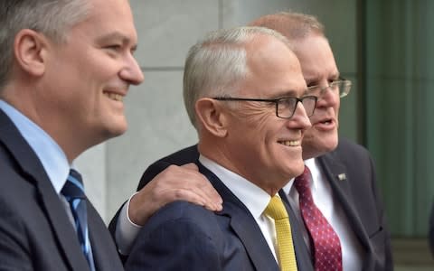Australia's Finance Minister Mathias Cormann (L), Prime Minister Malcolm Turnbull (C) and Treasurer Scott Morrison attend a press conference after the embattled leader narrowly survived a move to unseat him on Tuesday - Credit:  MARK GRAHAM/AFP