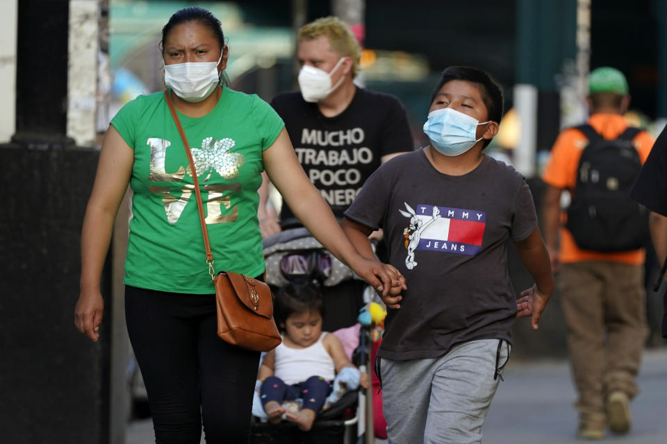 FILE — In this May 19, 2021 file photo. pedestrians wear protective masks during the coronavirus pandemic, in the Queens borough of New York. New York Gov. Andrew Cuomo and New York City Mayor Bill de Blasio have scheduled competing news conferences Monday, Aug. 2 amid rising COVID-19 case counts attributed to the highly contagious delta variant of the virus. (AP Photo/Frank Franklin II, File)