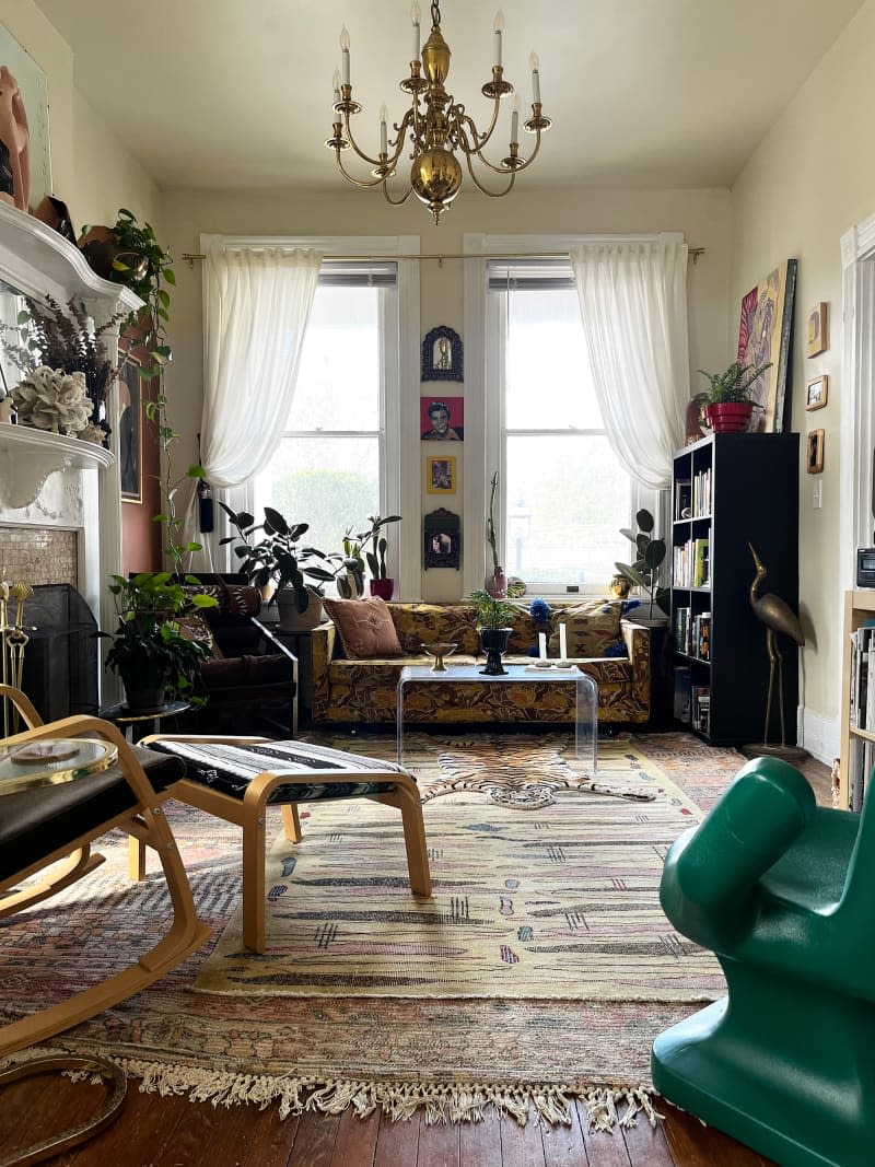 View of light yellow record room with patterned couch and multi-patterned rugs.