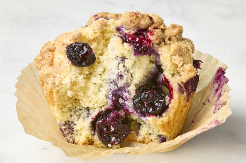 head on shot of the Ambitious Kitchen blueberry muffin with a bite taken out of it.