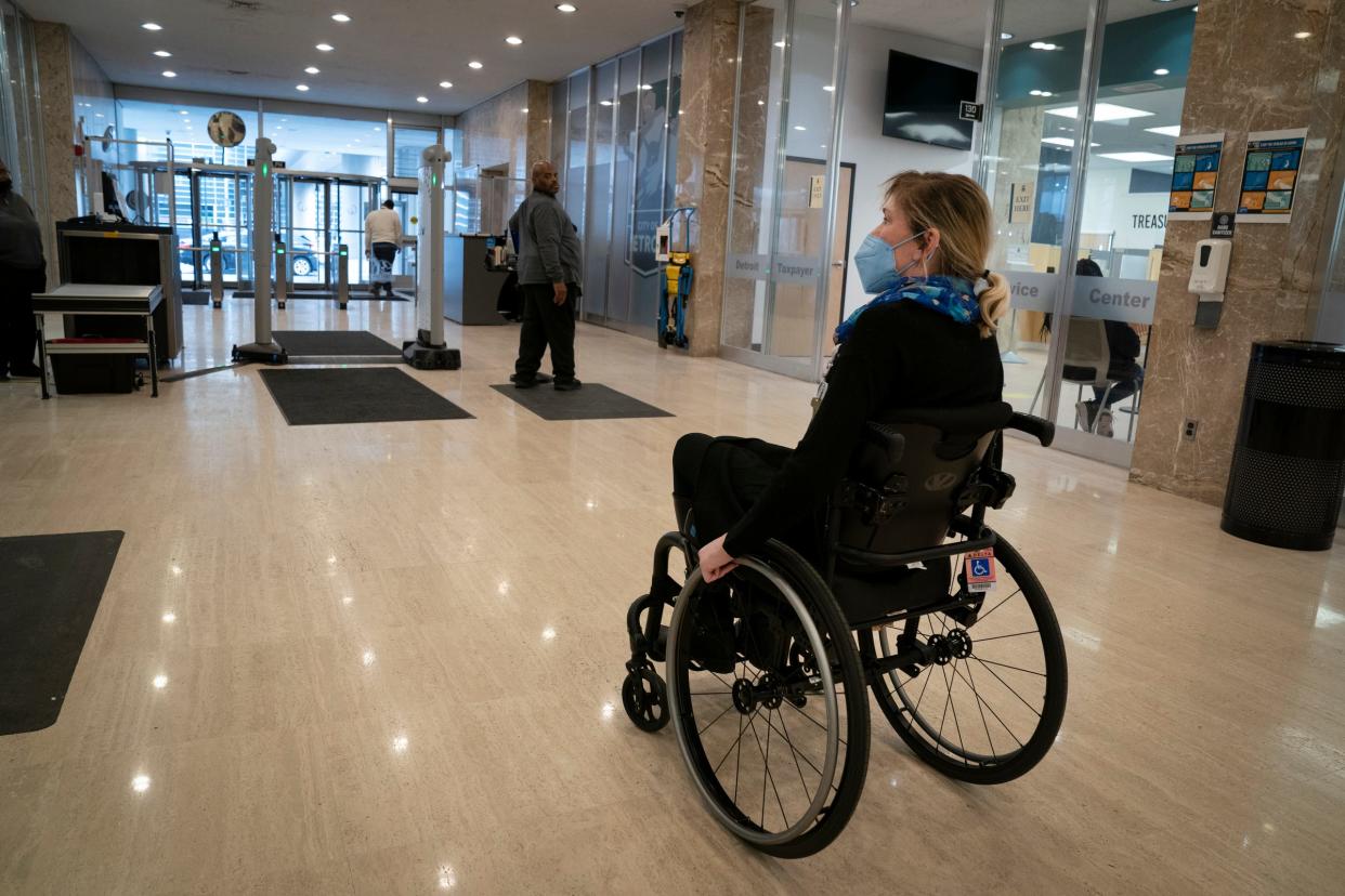 Jill Babcock of Detroit, talks about a security entrance on Jan. 5, 2023, of the Coleman A. Young Municipal Center where she is forced, in her wheelchair, to navigate the turnstiles instead of a glass swinging door that would be much easier.