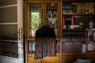 <p>A photo shows a shirt hanging near a bookcase marked with mud from floodwater in a house in Mandra, northwest of Athens, on Nov. 16, 2017, after heavy rainfall caused flooding early on November 15. (Photo: Angelos Tzortzinis/AFP/Getty Images) </p>