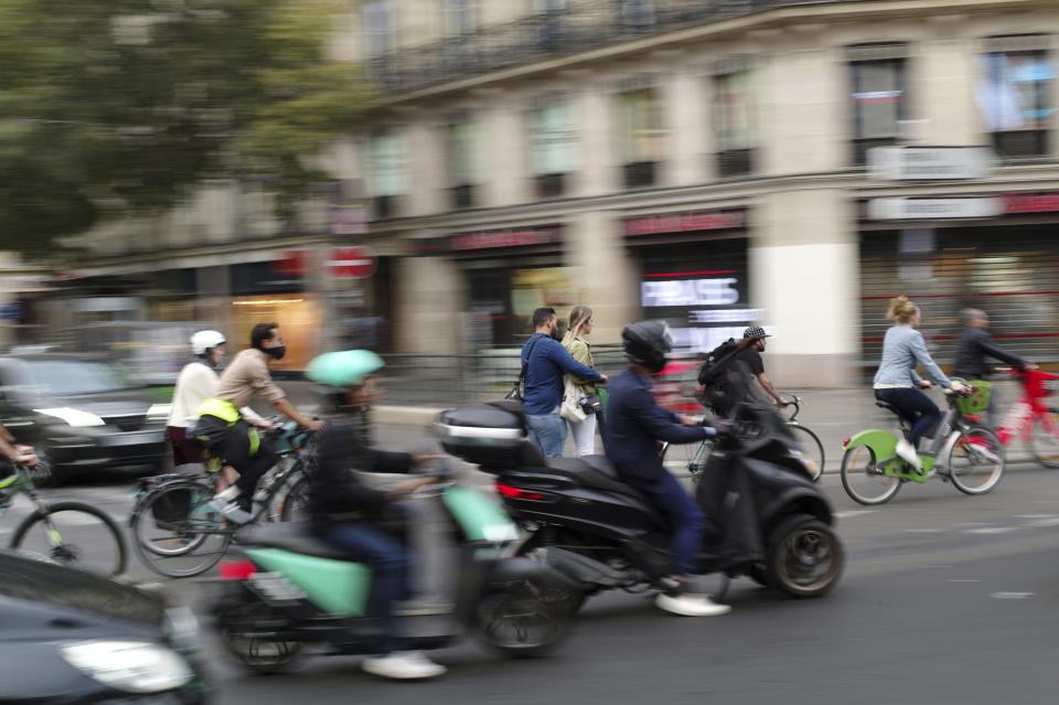 People ride bicycles and scooters in a street of Paris, Friday, Sept. 13, 2019. Paris metro warns over major strike, transport chaos Friday. (AP Photo/Thibault Camus)