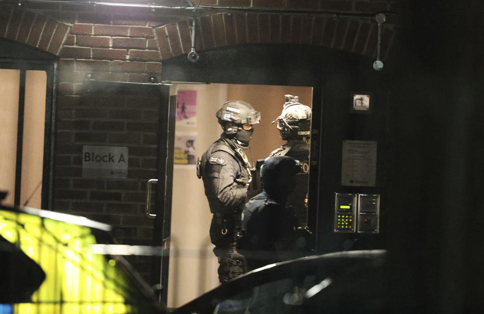 Armed police officers work at a block of flats off Basingstoke Road in Reading after an incident at Forbury Gardens park in the town centre of Reading, England, Saturday, June 20, 2020. Several people were injured in a stabbing attack in the park on Saturday, and British media said police were treating it as “terrorism-related.” (Steve Parsons/PA via AP)