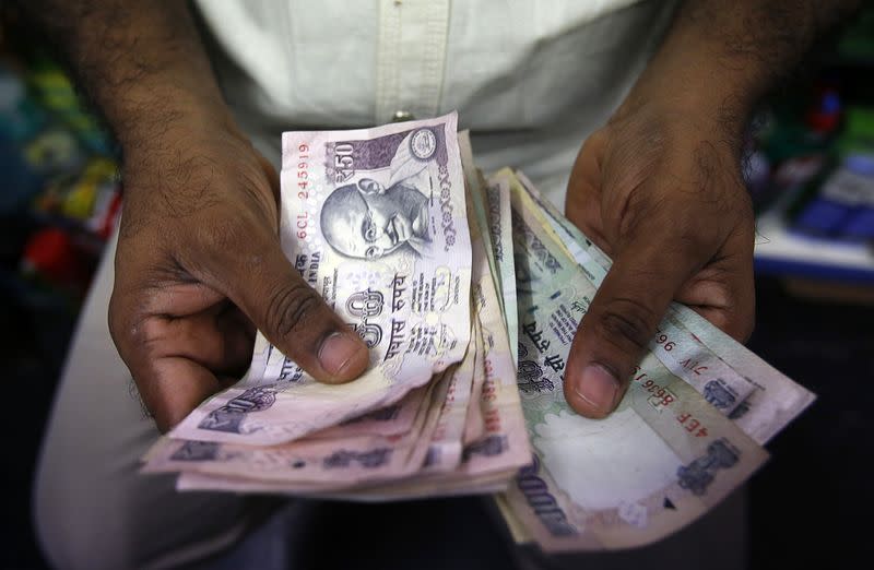 A private money trader counts Indian Rupee currency notes at a shop in Mumbai